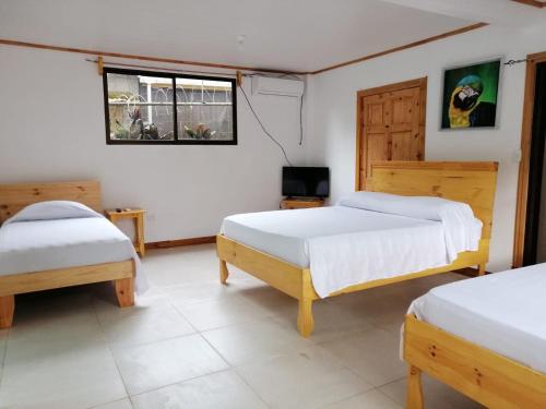 a bedroom with two beds and a television in it at Hotel El Congo in Drake