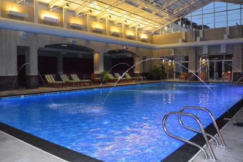 - une grande piscine avec 2 chaises dans un bâtiment dans l'établissement Seven Feathers Casino Resort, à Canyonville