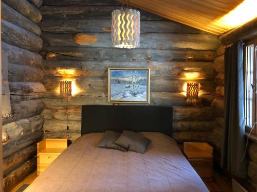 una camera con un letto su una parete in legno di Kuusiruka a Ruka