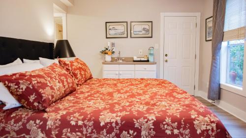a bedroom with a bed with a red blanket at Meranova Guest Inn in Dunedin