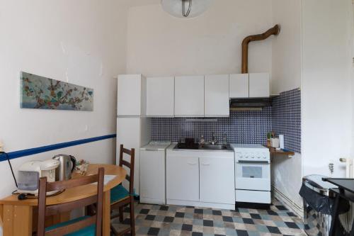 une petite cuisine avec des armoires blanches et une table dans l'établissement hôtel particulier SENS centre ville, à Sens