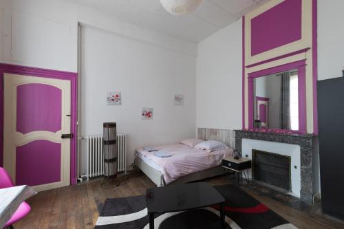 - une chambre avec un lit, une cheminée et un miroir dans l'établissement hôtel particulier SENS centre ville, à Sens