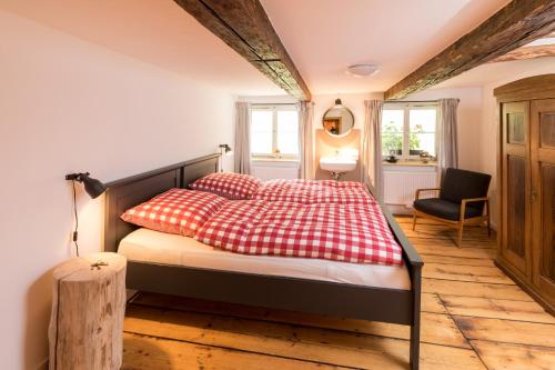 a bedroom with a bed with red and white pillows at WÄLDER: Quartier Dachsberg in Dachsberg im Schwarzwald
