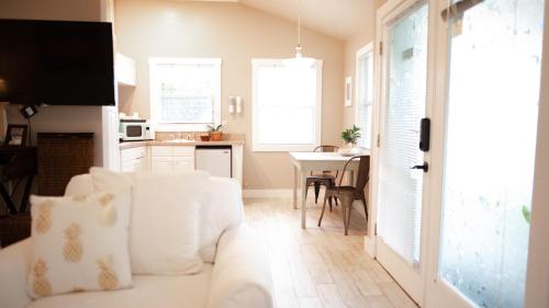 a living room with a white couch and a kitchen at Meranova Guest Inn in Dunedin