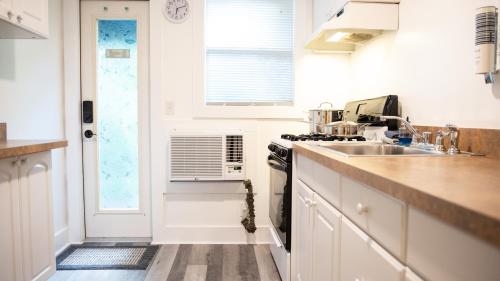 a white kitchen with a sink and a stove at Meranova Guest Inn in Dunedin