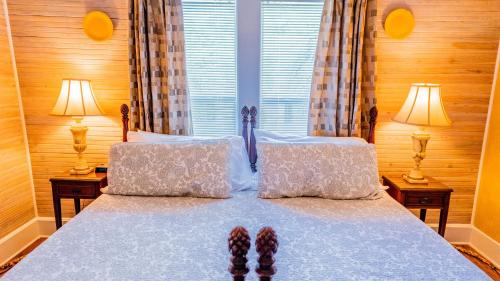 a bedroom with a bed with two lamps and slippers on it at Meranova Guest Inn in Dunedin