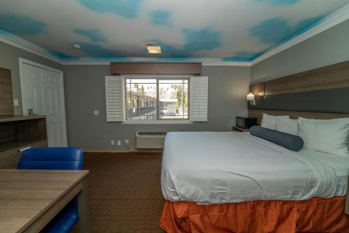 a hotel room with a bed and a window at Hollywood Palms Inns & Suites in Los Angeles