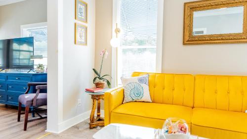a living room with a yellow couch and a blue dresser at Meranova Guest Inn in Dunedin