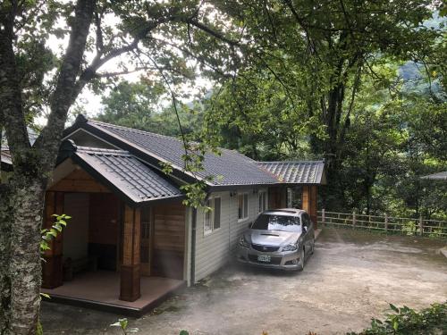 a car parked in front of a small house at 溪景生態農莊 桃園市民宿037號 in Hualing