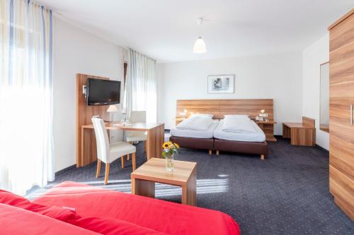 a hotel room with a bed and a desk at Hotel Krone Straßdorf in Schwäbisch Gmünd