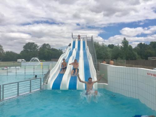 um grupo de pessoas em um toboágua em uma piscina em La Vieille Distillerie em Matha