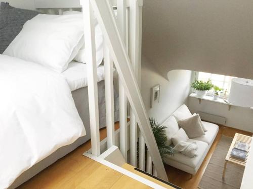 a bedroom with a white bunk bed and a white chair at Roost Pursimiehenkatu in Helsinki