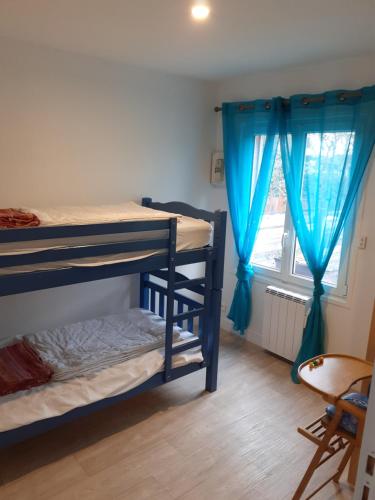 a bedroom with two bunk beds and a window at Maison familiale avec jardin au coeur du d day in Port-en-Bessin-Huppain