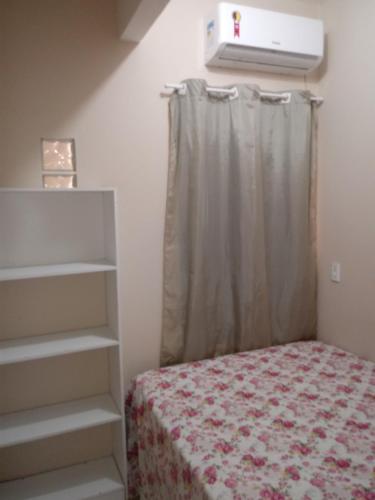 - une chambre avec un lit et une fenêtre avec un rideau dans l'établissement Casa Larithur, à Beberibe