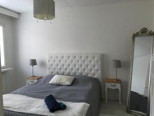 - une chambre avec un grand lit et un miroir dans l'établissement Tyylikäs rivitaloasunto Lohjalla, à Lohja