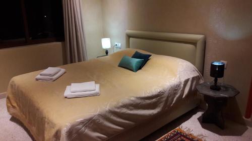 a bedroom with a bed with towels on it at Le Chêne d´Azrou in Azrou