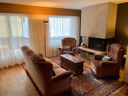 克萊恩 蒙塔納的住宿－La Residence-Your home away from home in Crans-Montana，客厅配有两把椅子和壁炉