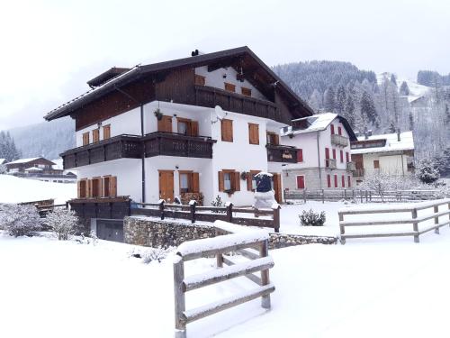 a house in the snow with a fence at CasaSabry in San Nicolò di Comelico