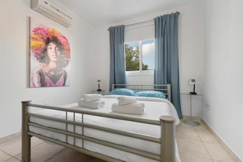 a bedroom with a bed with a painting on the wall at Glabur Stays - The Cozy Atelier - Nicosia City, Free Parking & Wifi, Welcomes You!!! in Nicosia