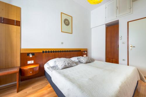 a bedroom with a bed with a wooden headboard at Kaboga street Rooms in Dubrovnik