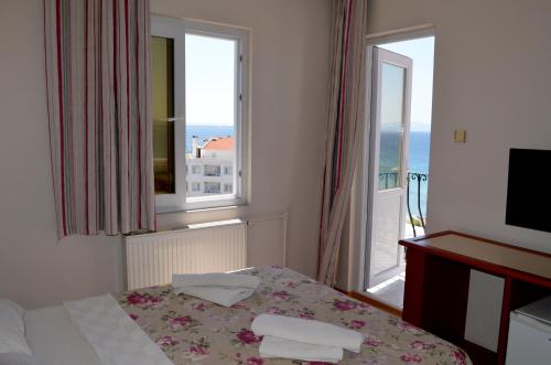 a hotel room with a bed and two windows at Grand Milano Hotel in Ayvalık