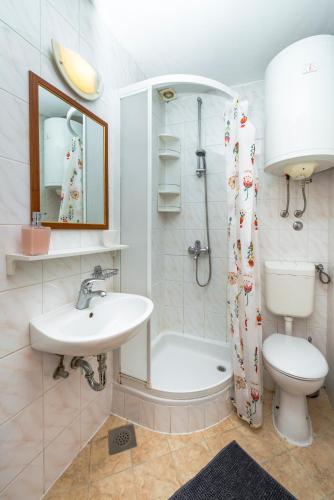 a bathroom with a sink and a toilet and a shower at Kaboga street Rooms in Dubrovnik