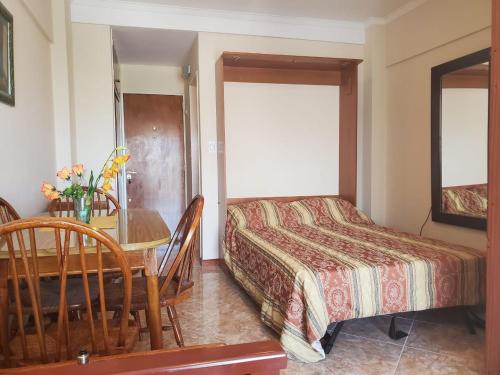 um quarto com uma cama e uma mesa e uma mesa e cadeiras em Paseo Aldrey em Mar del Plata