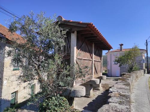 a small building with a wooden roof on a street at Casa do Canastro in Vouzela