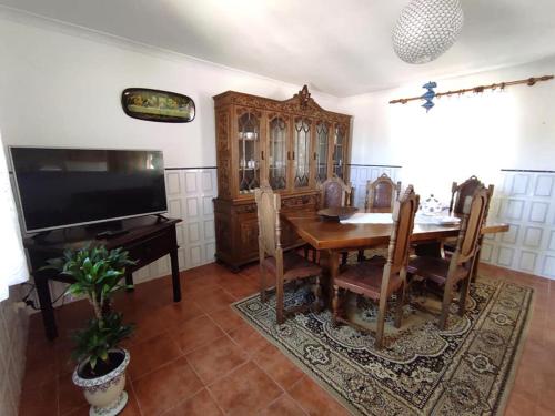 a dining room with a table and a television at Casa do Canastro in Vouzela