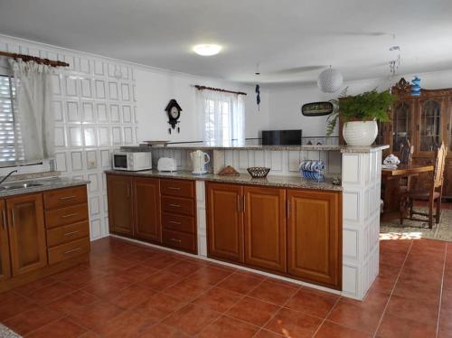 a large kitchen with wooden cabinets and a counter top at Casa do Canastro in Vouzela