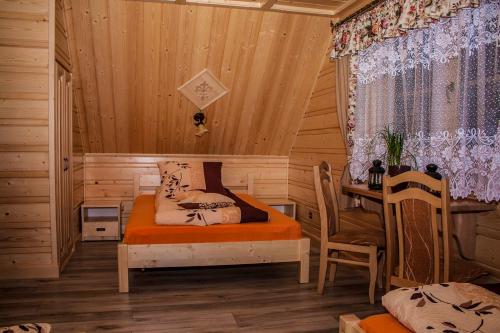 SablówkaにあるChatka Pod Laskiem - Domki w górachのベッドルーム1室(ベッド1台、テーブル付)