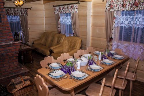 a wooden table in a room with a couch and a table and chairs at Chatka Pod Laskiem - Domki w górach in Soblówka