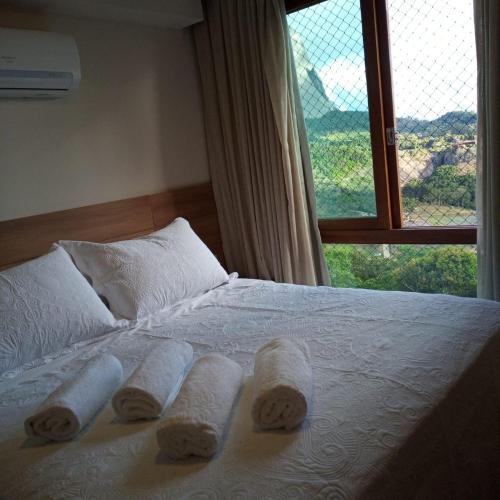 a bed with towels on it with a window at Loft Vista Azul - hospedagem as montanhas in Domingos Martins