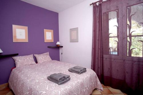 a bedroom with a bed with purple walls and a window at La Casa del Bosc, playa y golf - Salou in Salou