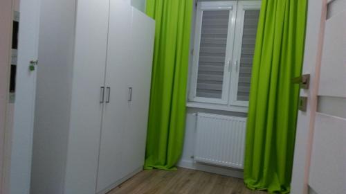 a room with green curtains and a window at Apartament u Gosi! in Giżycko