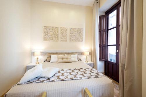 een slaapkamer met een groot bed en een raam bij REYES CATÓLICOS I in Granada