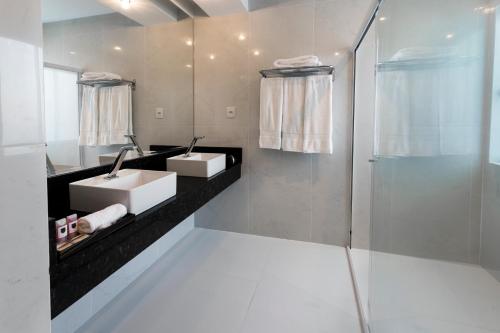 y baño con 2 lavabos y ducha. en Itacolomi Hotel, en Piçarras