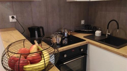 a kitchen with a basket of fruit on a counter at Apartament u Gosi! in Giżycko