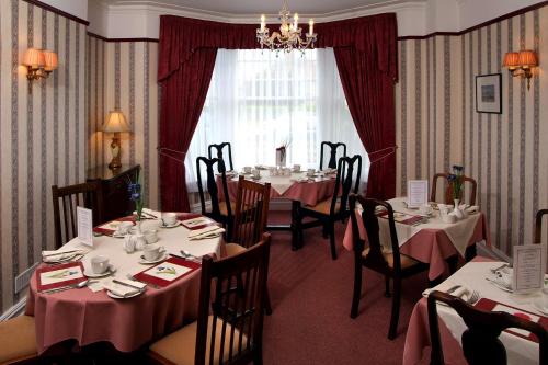 a dining room with tables and chairs and a window at Glendower House in Minehead