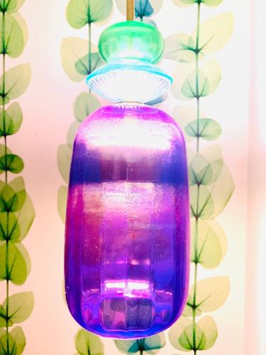 a blue and purple vase sitting in front of a wall at Sea to Sky Suites - Mijas Pueblo in Mijas