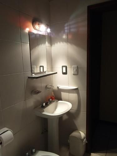 a bathroom with a sink and a toilet and a mirror at Portal del Sur in Chascomús