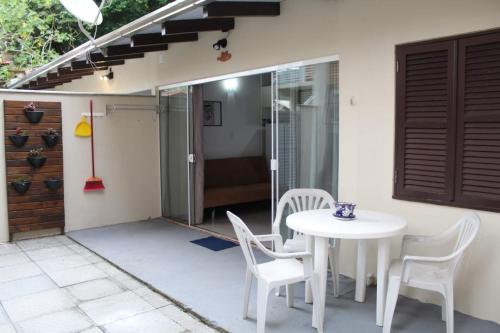 un patio con una mesa blanca y sillas en Residencial Annabel Apto 04, en Bombinhas