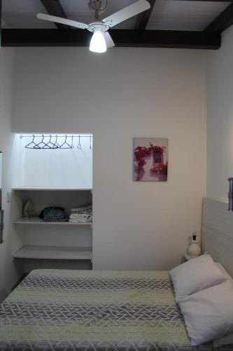 a bedroom with a bed and a ceiling fan at Residencial Annabel Apto 04 in Bombinhas