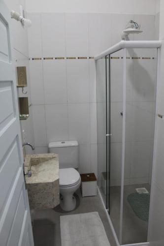 a bathroom with a toilet and a glass shower at Residencial Annabel Apto 04 in Bombinhas
