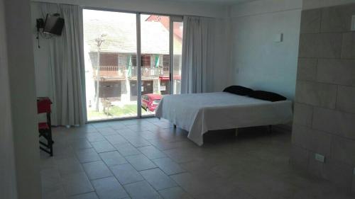 1 dormitorio con cama y ventana grande en Costanera Estudio en Santa Clara del Mar