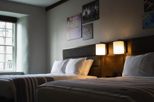 a hotel room with two beds and two lamps at Hotel Millwright in Amana