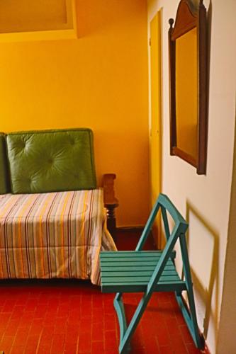 una silla verde sentada junto a una cama en una habitación en EDIFICIO CABO FRIO. I, en Pinamar