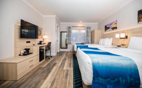 a hotel room with two beds and a flat screen tv at Comfort Inn Carmel By the Sea in Carmel