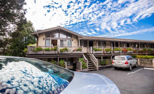a house with a car parked in a parking lot at Comfort Inn Carmel By the Sea in Carmel