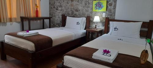 a hotel room with two beds and two tables at Ecohotel Bordones in Isnos
